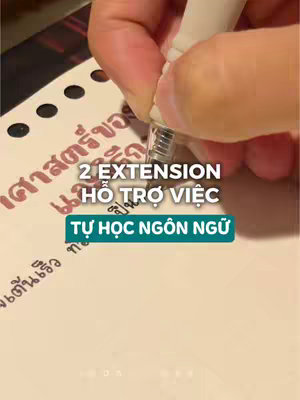 A hand holding a white pen is writing on a notepad. The notepad has Thai characters partially visible. Below the pen, a text overlay reads "2 EXTENSION HỖ TRỢ VIỆC" in white and bold font, over a teal box containing the text "TỰ HỌC NGÔN NGỮ".