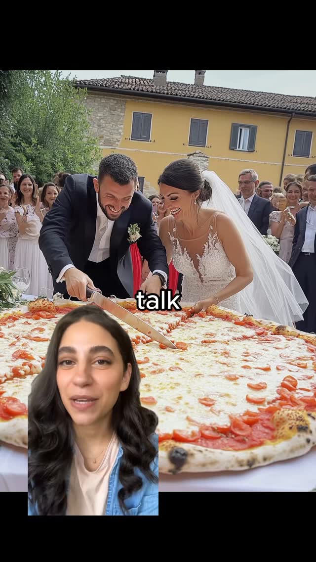 The image shows a wedding scene with the bride and groom cutting a giant pizza. The bride is wearing a white wedding dress and veil, smiling and cutting the pizza with a knife. The groom, in a black suit, is also cutting the pizza, smiling too. Behind them, there are guests in formal wear and a yellow building as the background. A woman is cropped in front with the 'talk' text overlay.