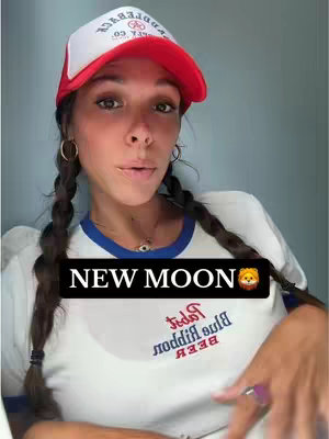 A woman in a white t-shirt and a red and white trucker hat looking at the camera. She has braided hair and is wearing hoop earrings and a necklace. The image has text overlaid that says "NEW MOON" in a black banner.