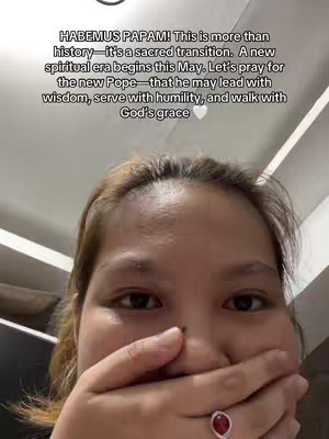 A selfie-style image focused on the upper half of a person's face. The person has light brown hair and is covering their mouth with their hand, revealing a ring. Text overlay in the upper portion of the picture