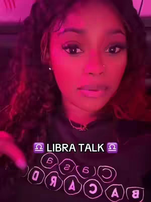 A woman with long, dark hair and a black top is centered in a close-up shot. The background is a gradient of purple and red. Overlay text in a purple box reads "Libra Talk" with libra symbols on each side.