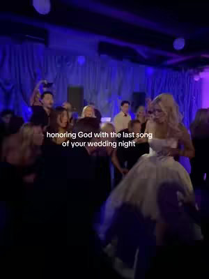 A scene from a wedding reception with a group of people, including a bride in a white dress and groom, gathered in a dimly lit area. The background features blue curtains, with lights illuminating the space. Text overlay indicates it's the last song of the wedding night.