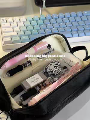 A top-down shot features a black pencil case, partially unzipped, filled with various stationery items such as pens, pencils, erasers, and stickers, arranged casually. A light-blue and white mechanical keyboard is visible in the background.