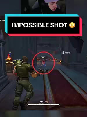 The image captures a gameplay scene from a video game, with the streamer in a small video overlay in the top right corner. The game environment has a futuristic architectural design, with hallways and doorways. A red circular pointer indicating a target within the game's field of view is in the center, around which are characters. The streamer is wearing a hat and looks surprised, and the text overlayed on the image states an 'IMPOSSIBLE SHOT'.