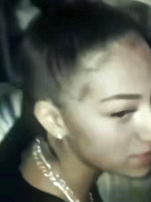 The cover image is a slightly blurred, medium close-up shot of a person, focusing on their face and upper chest. The individual has fair skin, and their hair is styled up and back, with a portion of the hair hanging down near the ear. They are wearing a black top, and a silver chain necklace is visible. The lighting appears to be soft with some shadows.