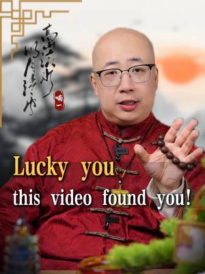 The cover image features a middle-aged man with glasses and a shaved head, wearing a red traditional Chinese-style shirt. He holds a string of prayer beads in his right hand, gesturing open, as if to show something. On the left, there is a blurred Chinese symbol, and the overall background has a soft, blurred effect. Text overlayed in yellow, reads 'Lucky you, this video found you!'