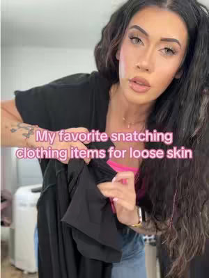 A woman with long dark hair and makeup holds a black shirt in front of her, with text overlayed. The background appears to be a room with a washing machine visible.
