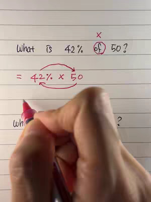 A person's hand writing a math problem on lined paper. The problem involves calculating a percentage of a number using arrows to demonstrate how to switch the numbers.