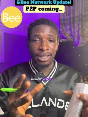A man is centered in a medium shot, looking towards the camera as he speaks. The background is a blurred, dark violet. He is wearing a black and white top. A green pen is held in one hand, a white item is in the other. Overlaying the top-left is a yellow circular image with the word 'Bee' in white within it, and above the man's head is a rectangular box with white text that reads '&Bee Network Update! P2P coming...'
