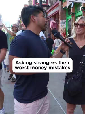 A man is interviewing a woman on a city street. The man is holding a microphone, and a white banner with black text reading "Asking strangers their worst money mistakes" is overlayed on the scene.