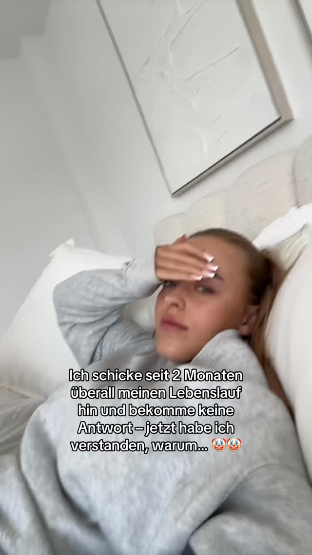 A young woman lies in bed, her head resting on a white pillow; she is wearing a gray sweater. Her hand is raised to her forehead in a gesture of frustration or contemplation. Text overlays the image, written in German.