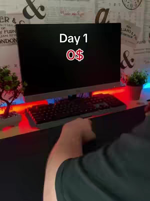 A person is setting up a desk for trading, in day one, with a screen, keyboard, and an RGB light setup.