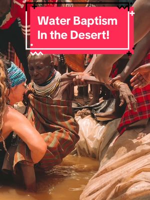 The cover image captures a water baptism scene in a desert setting. The focal point is an older person being supported by multiple people in a body of water, likely a river or a stream, in a desert-like environment. The image is warmly lit, potentially during the golden hour, with a red bar overlay at the top containing white text that states the video focus: Water Baptism In the Desert! The individuals are wearing a variety of clothing, and the scene evokes a sense of religious ceremony.