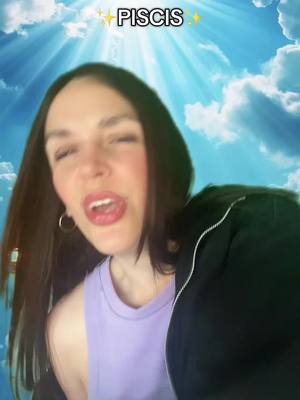 A woman with long dark hair is shown from the chest up. She is wearing a lilac top, open black jacket, and gold hoop earrings. The background is a bright blue sky with white clouds and sun rays, looking heavenly. The text overlay 'PISCIS' with sparkles, is in the top center.