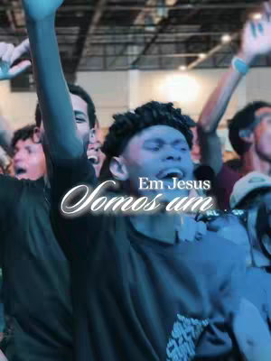 The image appears to be taken at a church event. A crowd of people is visible, with a man in the foreground with his arms raised, seemingly in worship or celebration. The lighting is blue and creates a sense of unity or a specific mood. The text overlay features a script-like font. The focus is on the participants and their gathering.