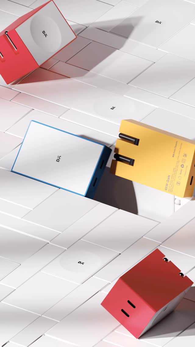 The cover image shows a stylized product shot. Several rectangular, colorful boxes, possibly product packaging, are scattered on a white, tile-like background. The boxes are mainly red, white, and yellow, with subtle branding in the form of the letters 'DA'. The scene is brightly lit, and the arrangement suggests a focus on product design and aesthetics.