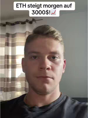 A man is centered in the frame, angled slightly upwards. He has short, light brown hair and a neutral expression. Above his head, there's a text overlay in a white box, and he's wearing a dark shirt against a light brown background. The overall composition appears clean and simple.