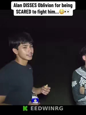 The cover image is a vertical still from what appears to be a video. The image features two young men, one of whom is centered and in focus. He is looking towards the camera and slightly smiling. He wears a black crew neck shirt with a small Nike logo is visible. The image is taken in a dark environment, possibly at night. The other person is partially visible. Text is overlaid on the top of the image, and a social media logo is at the bottom, indicating platforms like Instagram or TikTok.