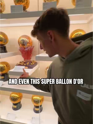 A young man in a green hoodie stands at a display case filled with golden trophies. The text overlay reads "AND EVEN THIS SUPER BALLON D'OR". 