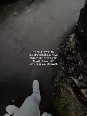 A person's leg and foot are seen from above, standing on a dark, wet surface that appears to be a bridge or walkway. The composition is centered on the leg, with the foot in white sneakers near the bottom. The dark water or pathway fills the space, and the side features a rocky outcrop. The text overlay on the top gives a feeling of emotional depth through its message.