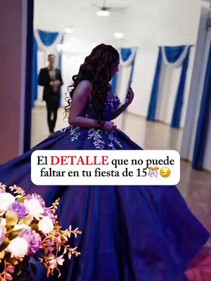 A woman in a blue gown from the back is looking into a phone. A man in a suit walks away in the background to the left. Text is overlaid on the image, partially obscuring the woman's back.