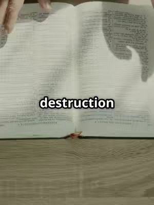 The cover image displays an open book on a wooden surface. The book is open, revealing its pages and a highlighted word “destruction” in a white rectangle. Over the pages, hands are visible, partially obscuring the text. The background has a wooden texture.