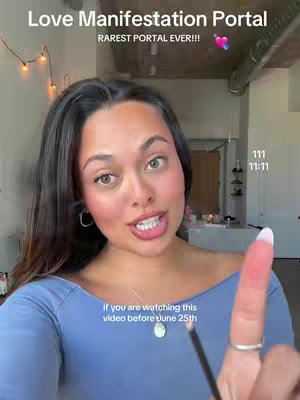 A woman with dark hair and fair skin looks directly at the camera. The upper part of her face is well lit. The background is a bright room featuring hints of other objects and a ceiling.