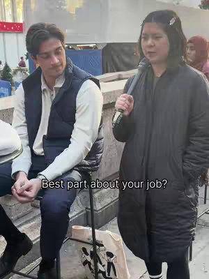 The cover image shows a woman holding a microphone and speaking, with a man next to her looking on. They appear to be outdoors in an urban environment.