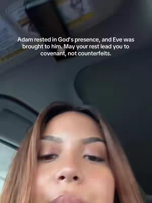 A selfie video filmed from inside a vehicle, showing a woman's face. The video has overlay of text, and the woman's brown hair is slightly out of focus, and there is a background of a vehicle interior around her.