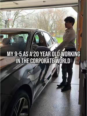 A young man in a light-colored shirt and dark pants stands beside a dark-colored car in a garage. The garage door is partially open, revealing trees and a basketball hoop in the background. Text overlayed on the image reads "MY 9-5 AS A 20 YEAR OLD WORKING IN THE CORPORATE WORLD".