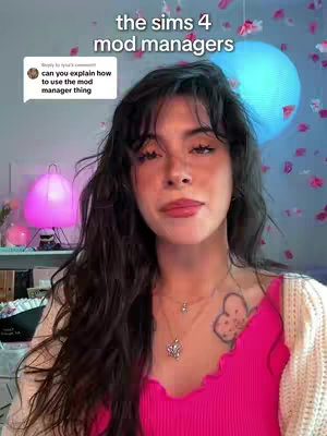 A woman with long dark hair and wearing a pink top stands in front of a blurred backdrop. The top text overlay reads: "THE SIMS 4 MOD MANAGERS". In the image there is a comment box and a round lighting fixture. The woman is looking directly at the camera and smiling.