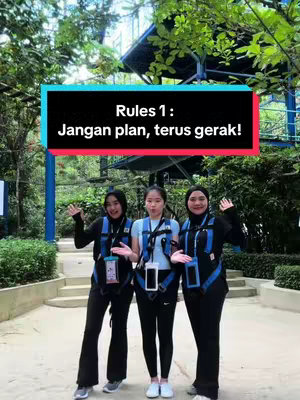 Three young women stand in front of a blurred outdoor setting, wearing harnesses. A rectangular text overlay at the top has the text 'Rules 1: Jangan plan, terus gerak!'