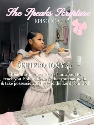 A woman in a light pink bathrobe stands in front of a mirror in a well-lit space. Text overlays are present: "The Speaks Scripture" and "EPISODE 5" at the top, and a Bible verse excerpt from Deuteronomy 4:1 is at the bottom. Her hands are up near her face, and some light-colored items are hanging behind her.
