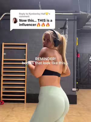The cover image features a woman in workout attire, facing away from the camera while looking over her shoulder. She’s wearing a black sports bra and light green leggings. Her blonde hair is pulled back, and she has headphones around her neck. The background is a gym setting with exercise equipment visible.
