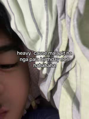 A close-up shot of a person lying in bed, partially covered by a striped blanket. The person's face is visible, with text overlayed in the image.