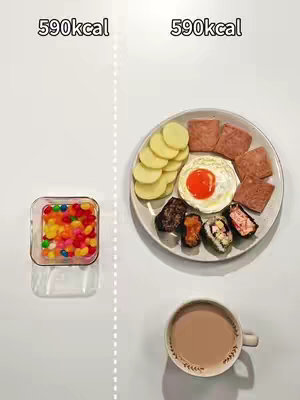 A top-down view showcases a split image. On the left, a clear glass square contains colorful candies. On the right, a plate holds a variety of foods including sliced potatoes, fried egg, Spam, and sushi-like rolls, with a teacup placed at the lower, right side. Above the plate is written the 590kcal.