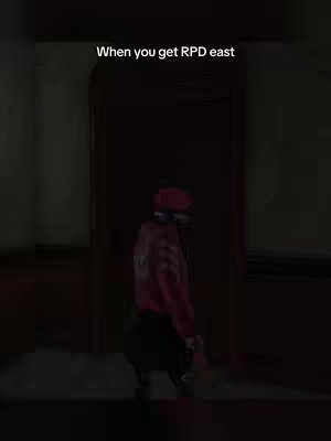 A character from the game Dead by Daylight stands in a dimly lit hallway, facing away from the camera. Text overlayed at the top says "When you get RPD east". The character wears a red jacket and hat. The background is dark with brown walls and door.
