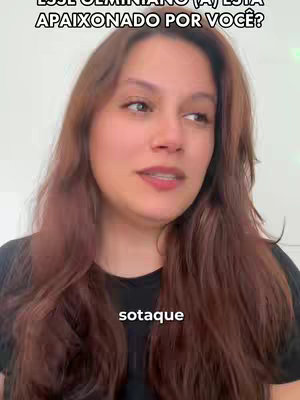 A woman with long brown hair is centered against a wall, looking upwards. The text "ESSE GEMINIANO (A) ESTÁ APAIXONADO POR VOCÊ?" appears above her head, while the word "sotaque" is overlaid at the bottom of screen.
