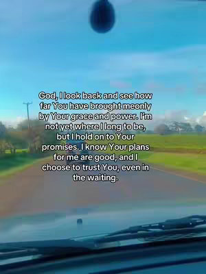The image captures a view from inside a vehicle, looking out onto a road with a clear blue sky. Text is overlaid, expressing faith and trust.