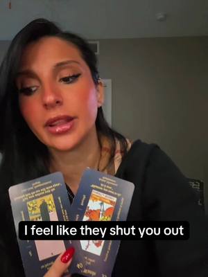 A woman with dark hair holds two tarot cards in front of her. She has makeup on, and red nail polish. The hook is displayed in a black box below the cards.