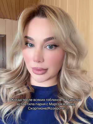 A close up shot of a woman with long wavy blonde hair and blue eyes. She has full makeup and is looking at the camera with a neutral expression. Text is overlaid at the bottom which describes a dating scenario.