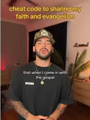 A man wearing a camouflage cap and a black t-shirt is positioned slightly off-center, facing the camera. Above him, overlapping his head, are the words "cheat code to sharing my faith and evangelism" in a yellow font. Below the man, overlapping his chest, is the text "that when I come in with the gospel" in white font. The background shows an interior room with a dark curtain and a shelf. The overall image is illuminated with warm lighting.