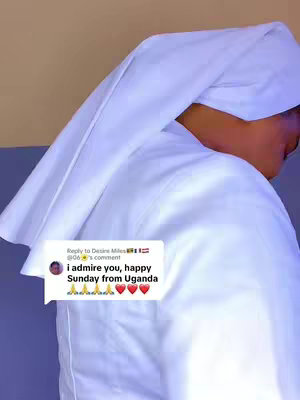 The image shows a person covered in a white cloth. The person is facing away slightly, with the cloth draped over their head and shoulders. A text overlay is present, appearing to be a comment or reply.