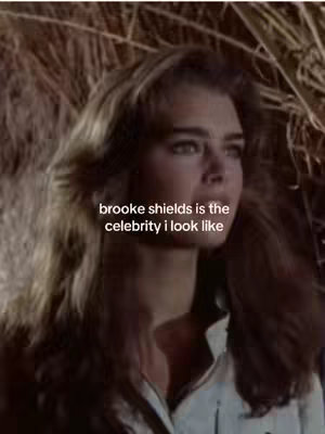 The image is a medium shot of a woman with long, light brown hair and a light-colored shirt. The woman appears to be Brooke Shields. The background is blurred, suggesting a natural outdoor setting.