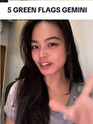 A young woman is shown from the chest up smiling and talking to the camera; her hand is extended toward the viewer as if grabbing.