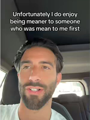 A close-up shot of a man with dark hair and a beard, wearing a white t-shirt, sitting in a car. The background is slightly blurred, focusing on the man's face and upper body. Text overlay is present at the top of the image.