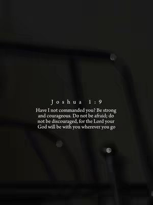 A blurred, dark image, with the text of Joshua 1:9 in a center-aligned, white font with a clean sans-serif font, and faint lights that seem to be reflected.
