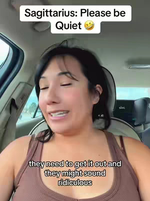 A woman in a car is looking at the camera and talking, with superimposed text on the image.