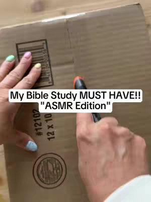 A person's hands are seen in close-up, holding a marker, over a light brown cardboard box; text is overlayed.