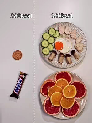 The image is split vertically, showing two meals with equivalent caloric values (380kcal) side by side. On the left, a round cookie and a Snickers bar are present. On the right, a plate contains cucumber slices, an egg (sunny-side up), chicken breast pieces, and sliced mushrooms, and another plate contains orange and grapefruit slices. The food items are arranged on a white surface.